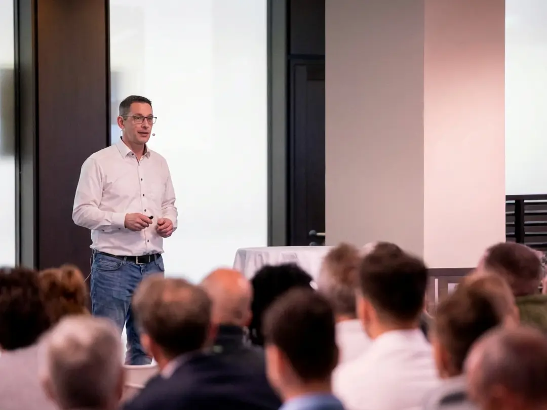 Ein Betotech Mitarbeiter hält einen Vortrag vor einem Publikum in einem Konferenzraum.